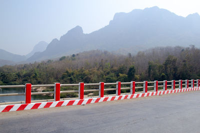 Road sign by mountains against sky