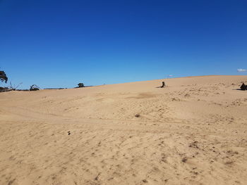 Scenic view of desert against clear blue sky