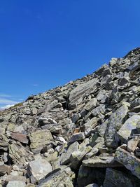 Low angle view of rock formation against clear blue sky