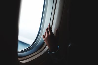 Close-up of hand against window