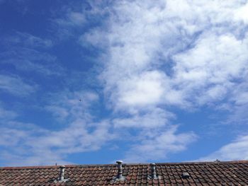 Low angle view of house roof against sky