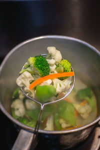 Close-up of vegetables in strainer over cooking utensil