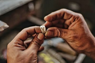 Cropped hands of man holding rings 