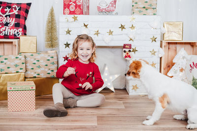 Little girl and jack russell dog at home. christmas time