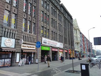 People on street against buildings in city