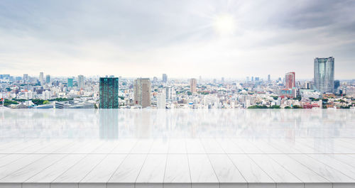 Modern buildings in city against cloudy sky