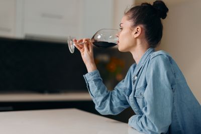 Young woman drinking water while sitting at home
