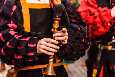 Midsection of musician holding instrument