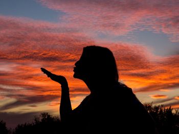 Silhouette woman against sky during sunset