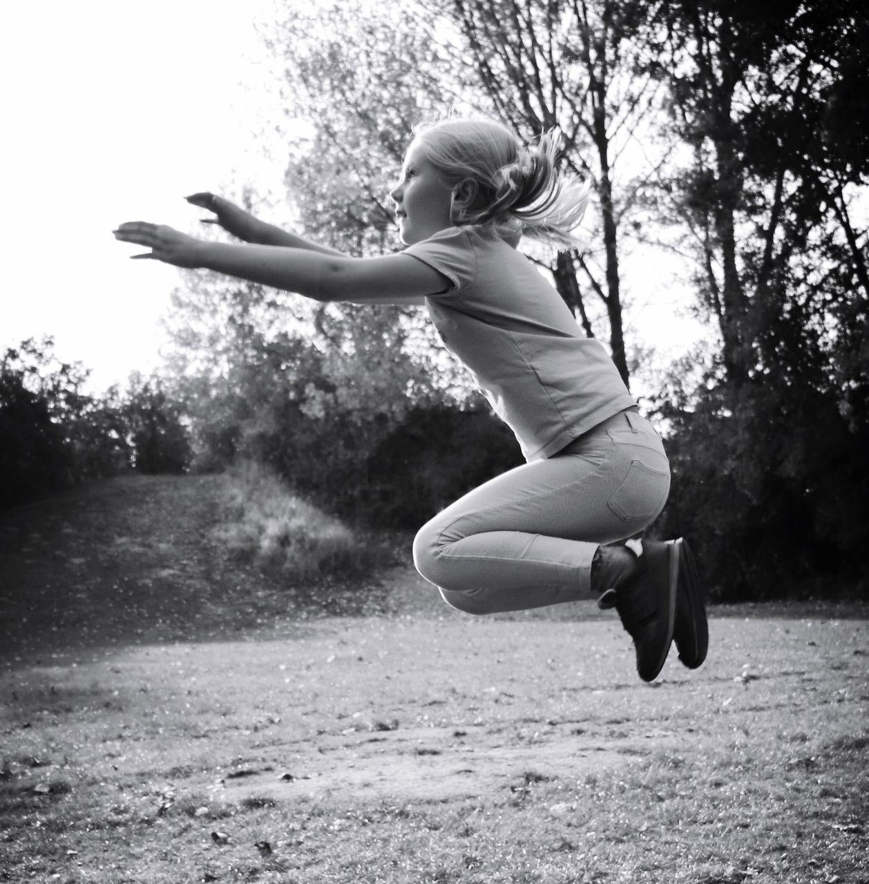 one person, full length, motion, real people, leisure activity, plant, lifestyles, day, mid-air, jumping, nature, women, casual clothing, field, side view, females, child, tree, girls, human arm, outdoors, limb, excitement, hairstyle