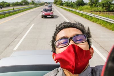 Portrait of woman with sunglasses on road. asian man taking selfie on the roof of the car