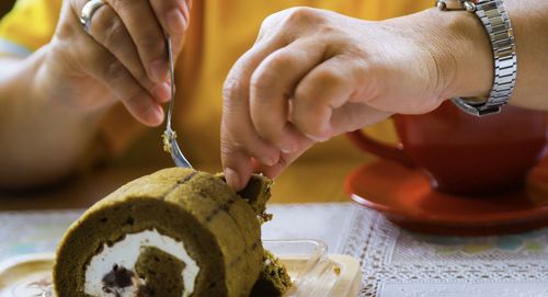 Midsection of woman holding cake on table