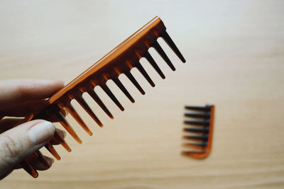 Close-up of hand holding broken comb