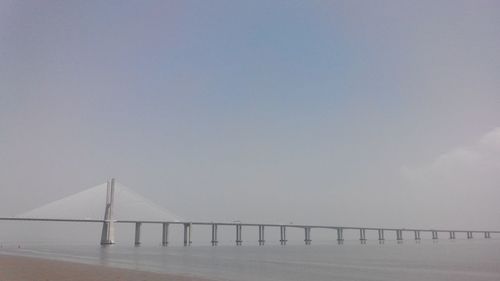 Vasco da gama bridge over tagus river against sky