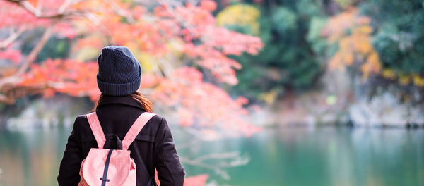 Rear view of man standing by lake