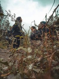 Group of people on field against trees in forest