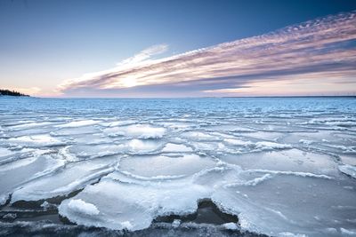 Scenic view of frozen sea against sky during sunset