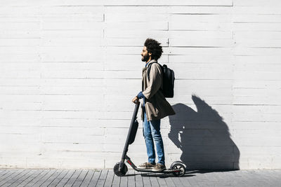 Man with backpack on e-scooter