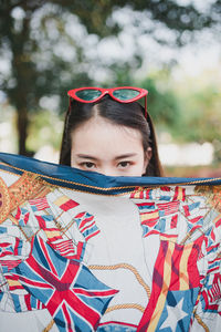 Portrait of young woman with colorful scarf against tree