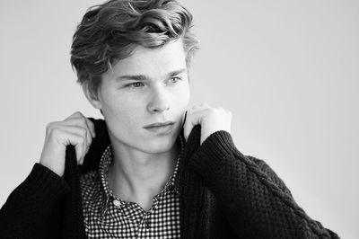 Young man looking away against white background