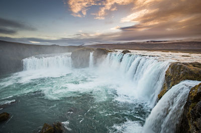 Scenic view of waterfall against sky