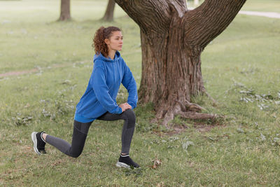 A european woman does sports in a park or a public place. warm-up and jogging in the fresh air