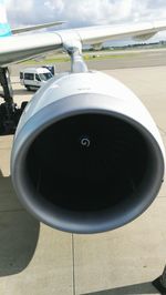 Close-up of airplane on runway against sky