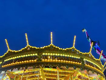 Low angle view of illuminated ferris wheel at night