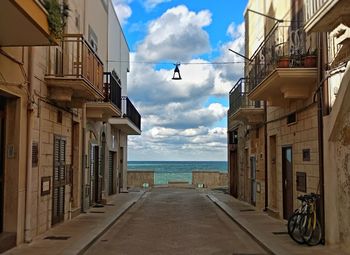 Street amidst buildings in city against sky