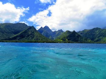 Scenic view of sea and mountains against blue sky