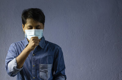 Health problem and people concept - unhealthy indian man coughing with nose mask on