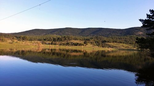 Scenic view of lake and mountains against clear sky