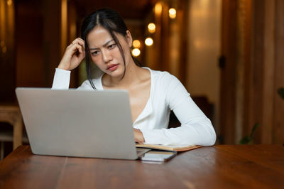 Portrait of woman using laptop at table