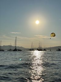 Sailboats in sea against sky during sunset