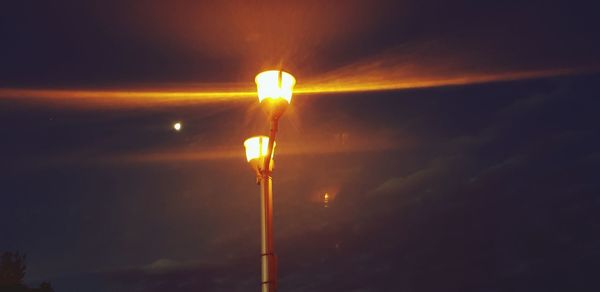 Low angle view of illuminated street light against sky at sunset