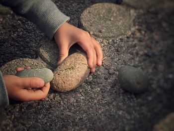 Cropped image of girl playing with stones