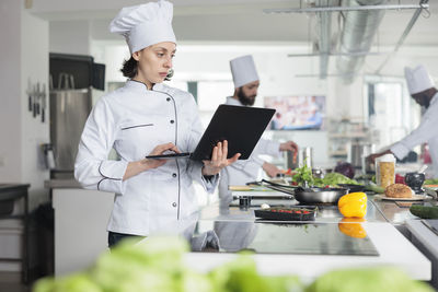 Chef using laptop in kitchen at restaurant