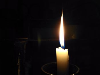 Close-up of lit candle in dark room