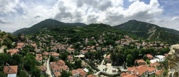 Panoramic view of townscape and mountains against sky