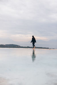 Man standing on beach against sky