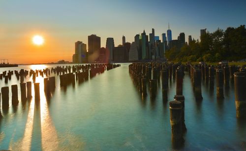 Panoramic view of sea and buildings against sky during sunset