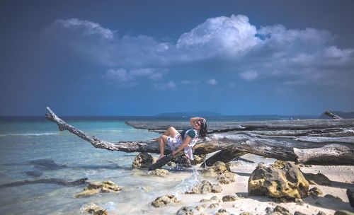 People on beach by sea against sky
