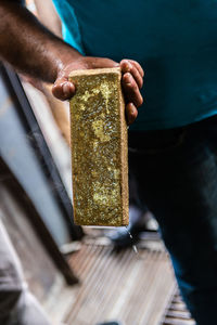 Midsection of man holding wet stone