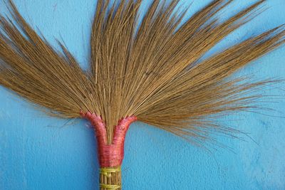 Broom against blue wall