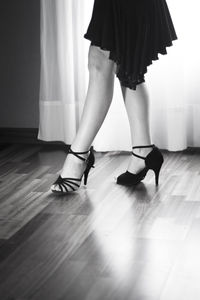 Low section of woman standing on hardwood floor