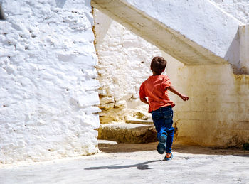 Rear view of man standing against wall