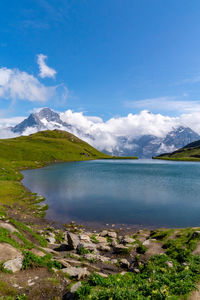 Scenic view of lake and mountains against blue sky