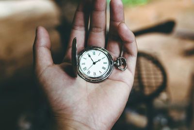 Close-up of hand holding pocket watch