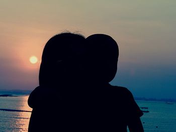 Close-up of silhouette man with heart shape against sky during sunset