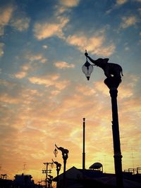 Silhouette statue against sky during sunset